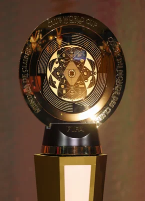 Home 5 A close-up of the Club World Cup 2025 trophy, featuring intricate circular patterns, reflective surfaces, and text.