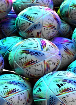 Home 4 A close-up pile of footballs, predominantly white with bright, colorful geometric patterns.